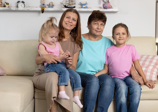 Foto oma und mama sitzen mit kindern zu hause auf der couch