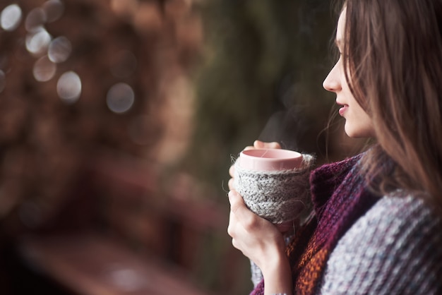 Omã, vestindo roupas de malha quentes, bebendo uma xícara de chá ou café quente ao ar livre