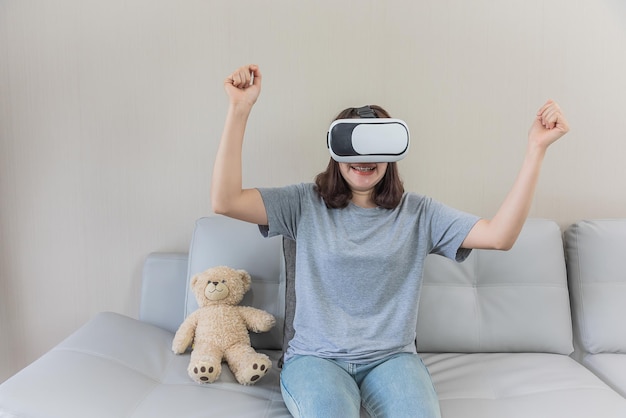 Omán asiático jugando un videojuego con gafas VR en casa