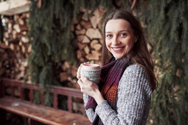 Oman, das draußen warme Strickkleidungstrinkbecher heißen Tee oder Kaffee trägt