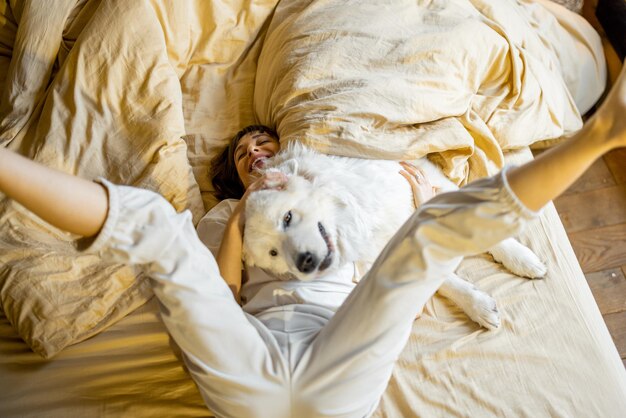 Omán jugando con su perro en la cama