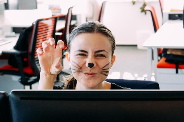 Oman en la oficina enmascarado como un gato para Halloween