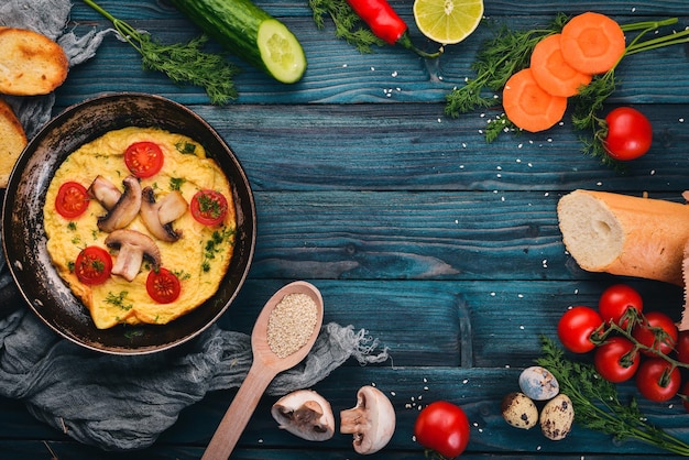 Omelete com cogumelos e legumes frescos e nozes em uma frigideira Em um fundo de madeira Vista superior Copiar espaço