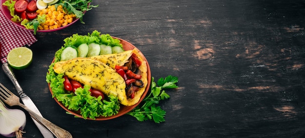 Omelete com cogumelos e legumes Ovos fritos em um fundo de madeira Vista superior Espaço para cópia grátis