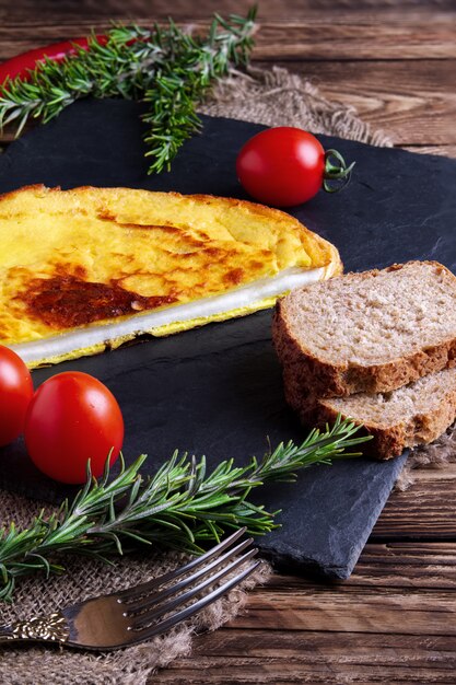 Omelete com pão integral e tomate fresco