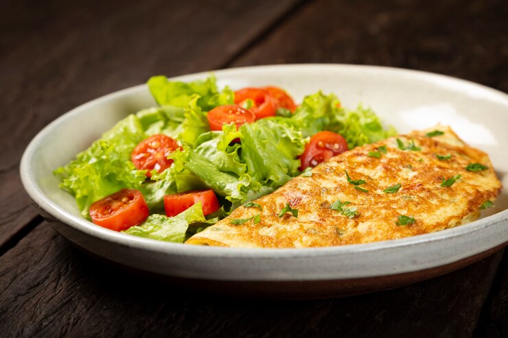 Foto omelete com queijo e salada de alface e tomate