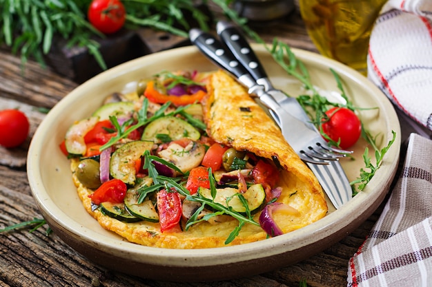 Omelete com tomate, abobrinha e cogumelos. Omelete de café da manhã. Comida saudável.