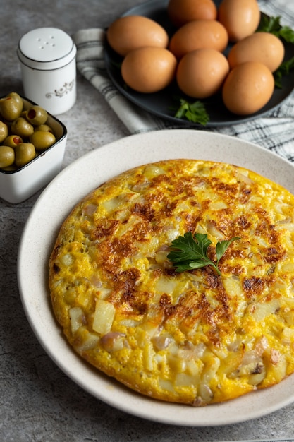 Omelete de batata com ovos servidos em mesa de mármore