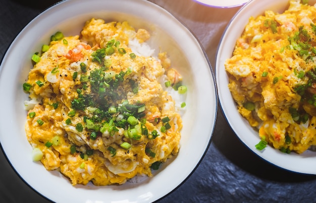 Omelete de camarão picado estilo asiático com arroz e cebola com luz do sol da manhã.