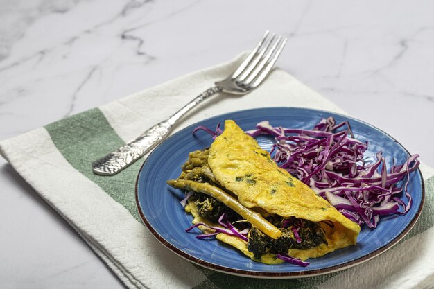 Omelete de espargos verdes caseiros saudáveis com espinafre e repolho roxo com espaço de cópia. Conceito de comida vegana