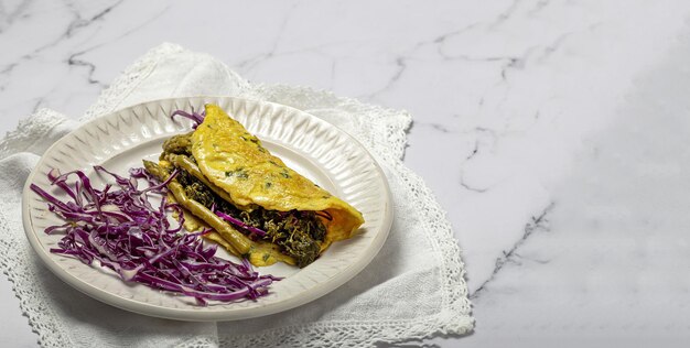 Omelete de espargos verdes caseiros saudáveis com espinafre e repolho roxo com espaço de cópia. Conceito de comida vegana