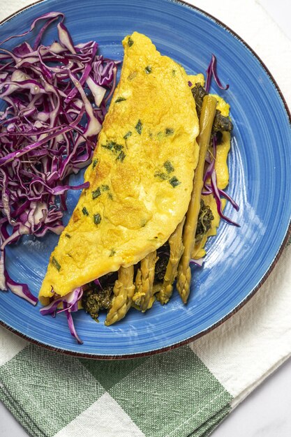 Omelete de espargos verdes caseiros saudáveis com espinafre e repolho roxo com espaço de cópia. Conceito de comida vegana