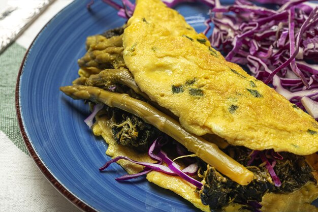 Omelete de espargos verdes caseiros saudáveis com espinafre e repolho roxo com espaço de cópia. Conceito de comida vegana