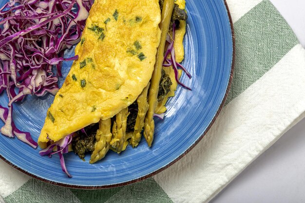 Omelete de espargos verdes caseiros saudáveis com espinafre e repolho roxo com espaço de cópia. Conceito de comida vegana