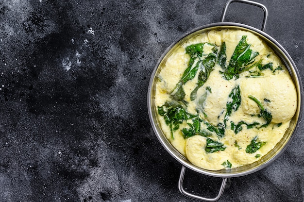 Omelete de espinafre e queijo italiano em uma panela.