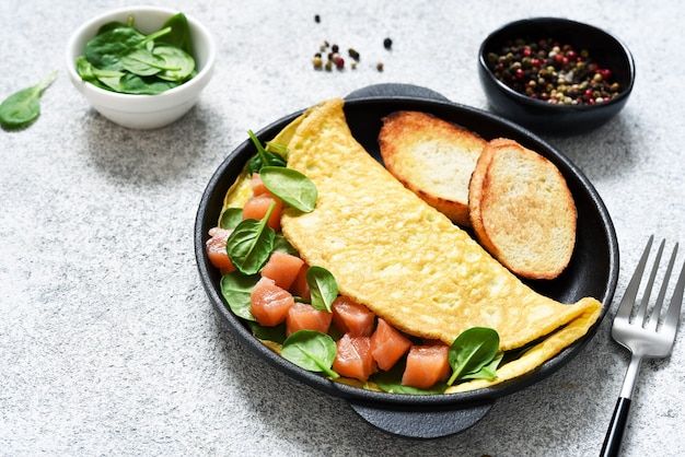 Omelete de salmão e espinafre com massa de pão no café da manhã.