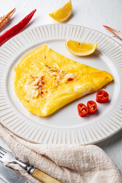 Omelete de seda de caranguejo malagueta, no prato, sobre fundo branco