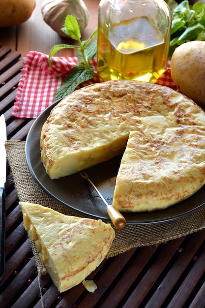 Omelete espanhola com batata e ovo, acompanhada de azeite