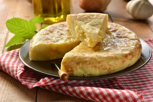 Omelete espanhola com batata e ovo, acompanhada de azeite