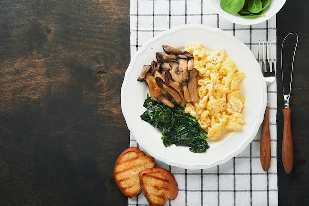 Omelete Espinafre cogumelo ostra e omelete de queijo ou fritada em fundo escuro de madeira velha Ideia de café da manhã Vista superior com espaço de cópia