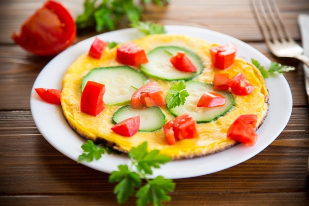 Omelete frita com tomates zucchini ervas em um prato