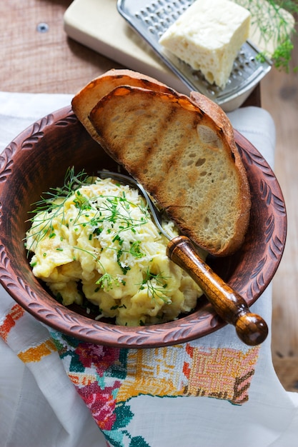 Omelete tradicional moldávio ou romeno com queijo, servido com pão sobre uma superfície de madeira.