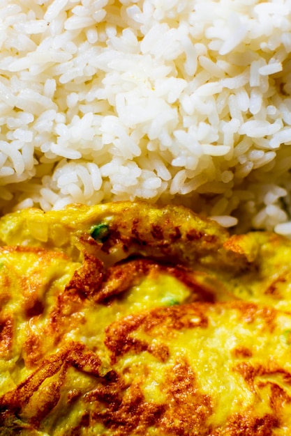 Omelett mit gefaltetem Ei, das auf dem heißen Reis auf einem Essteller gehalten wird, gesunde indische Ernährungsgewohnheit