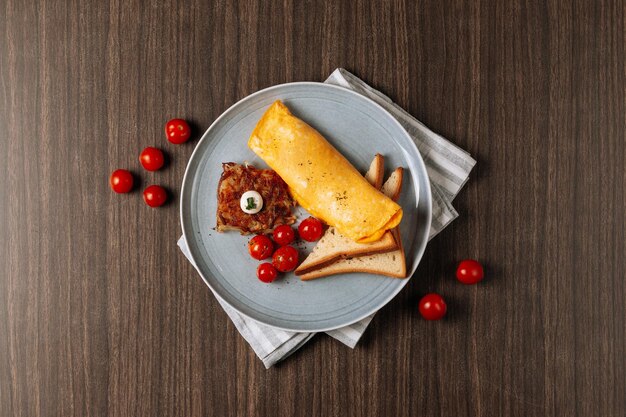 Omelett mit gezüchtetem Toast und Tomate lokalisiert auf Draufsicht des Holztischs