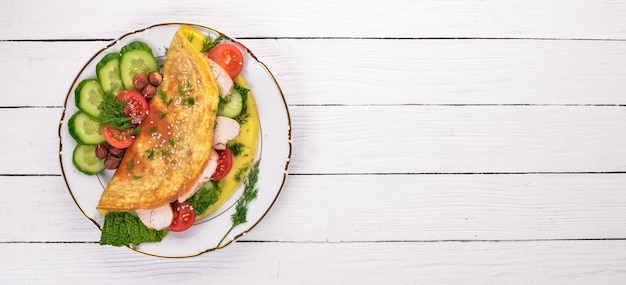 Omelett mit Hühnchen und frischem Gemüse und Nüssen Auf einem hölzernen Hintergrund Ansicht von oben Kopieren Sie Platz