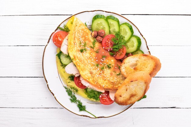 Omelett mit Hühnchen und frischem Gemüse und Nüssen Auf einem hölzernen Hintergrund Ansicht von oben Kopieren Sie Platz