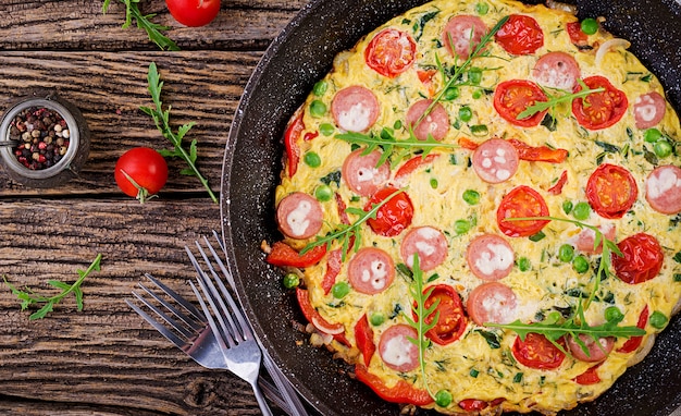 Omelett mit Tomaten, Wurst und Erbsen im rustikalen Stil