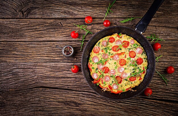 Omelett mit Tomaten, Wurst und Erbsen im rustikalen Stil