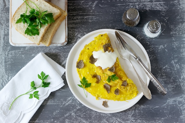 Omelett mit Trüffel und Petersilie, serviert mit saurer Sahne