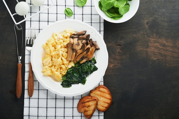 Omelett Spinat-Austernpilz und Käse-Omelett oder Frittata auf dunklem alten Holzhintergrund Frühstücksidee Draufsicht mit Kopierbereich