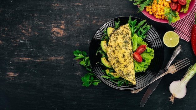 Omelette mit Gemüse und Avocados Spiegeleier auf einem hölzernen Hintergrund Draufsicht Freier Kopierbereich