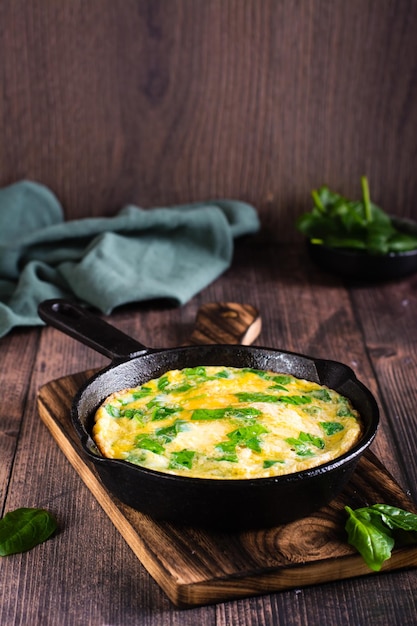 Omelette mit Spinat und Käse in einer Pfanne auf dem Tisch Ketogene Ernährung Vertikale Ansicht