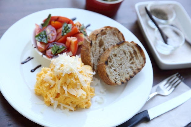 Omelette mit Tomaten und Brot auf Holzhintergrund