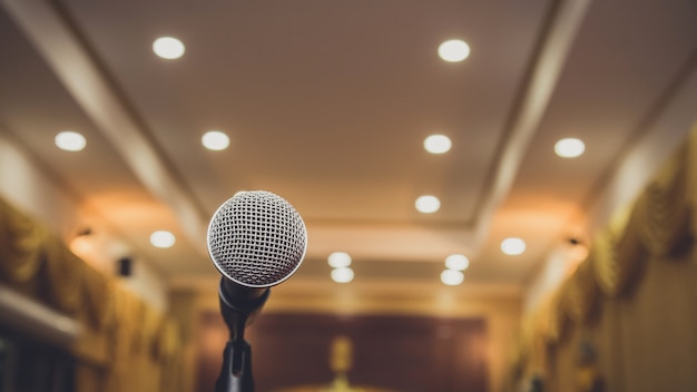 Onbstract micrófono borroso en la sala de seminarios o en la sala de conferencias, evento