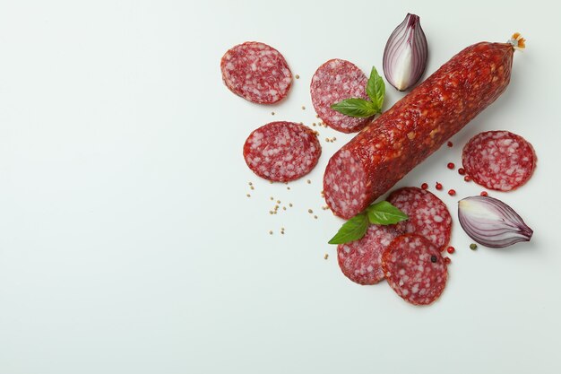 Ã Â¡oncept de comida sabrosa con salchicha de salami sobre fondo blanco