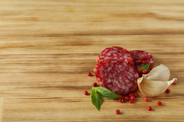 Ã Â¡oncept de comida sabrosa con salchicha de salami sobre fondo de madera