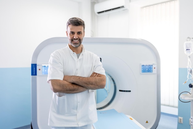 Foto oncologia de médico masculino confiante em ressonância magnética ou sala de tomografia computadorizada de um hospital moderno