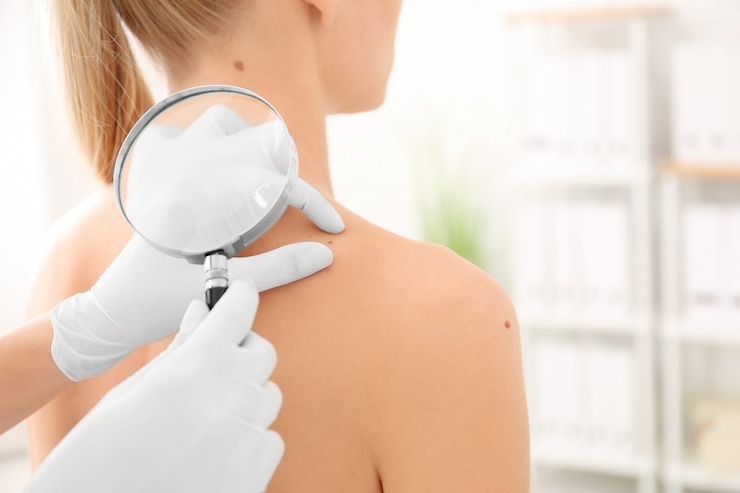 Foto oncólogo examina a la paciente con lupa en la clínica. conciencia del cáncer
