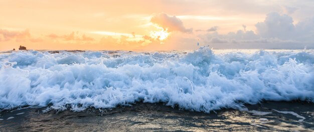 Onda de agua de mar cerca con fondo de cielo sunse