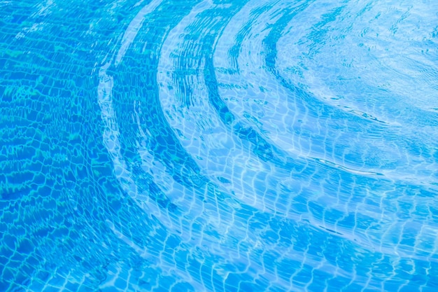 Onda de agua de textura en la piscina con reflejos soleados