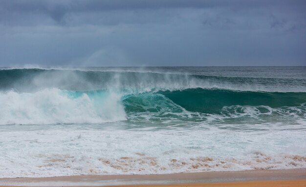 Onda azul na praia. Desfoque de fundo e manchas de luz solar. Fundo natural tranquilo.