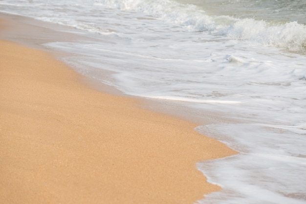 Onda de espuma macia e mar no fundo da praia