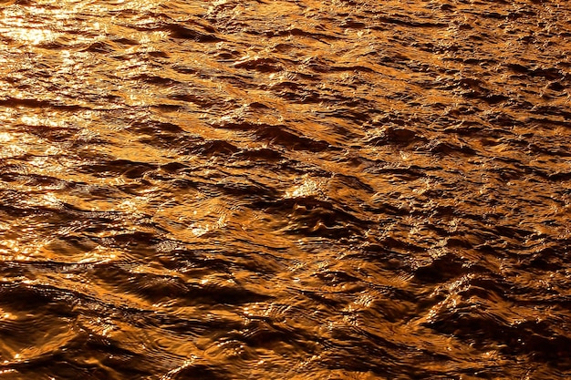 Onda de reflexão da luz solar do rio de fundo de ouro de água