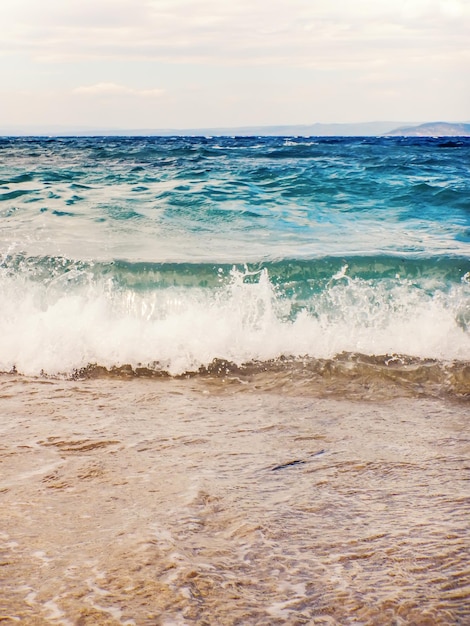 Onda do oceano azul na areia da praia Fundo de verão