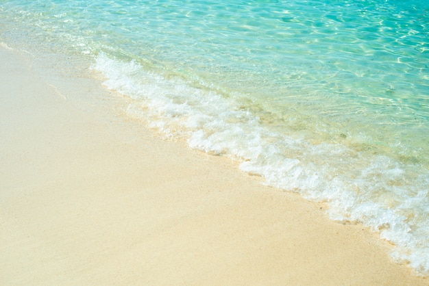 Foto onda macia do oceano azul na praia arenosa.