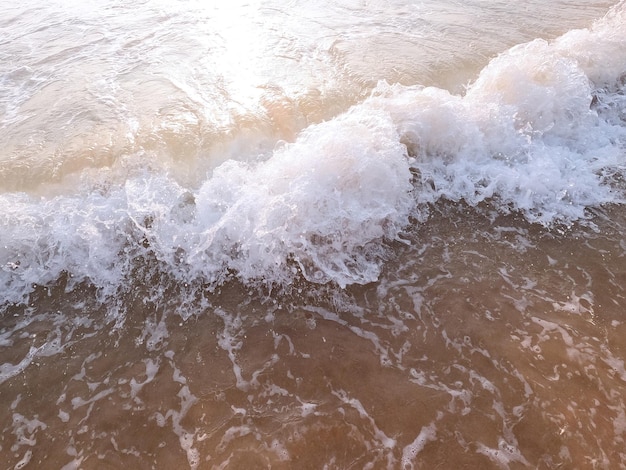 Onda oceânica suave em uma praia de areia limpa close-up